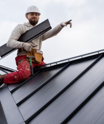 Roof worker installing metal roof